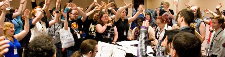 Room full of people singing and waving hands to piano tunes from Buffy - photograph by Curious Magpie Photography